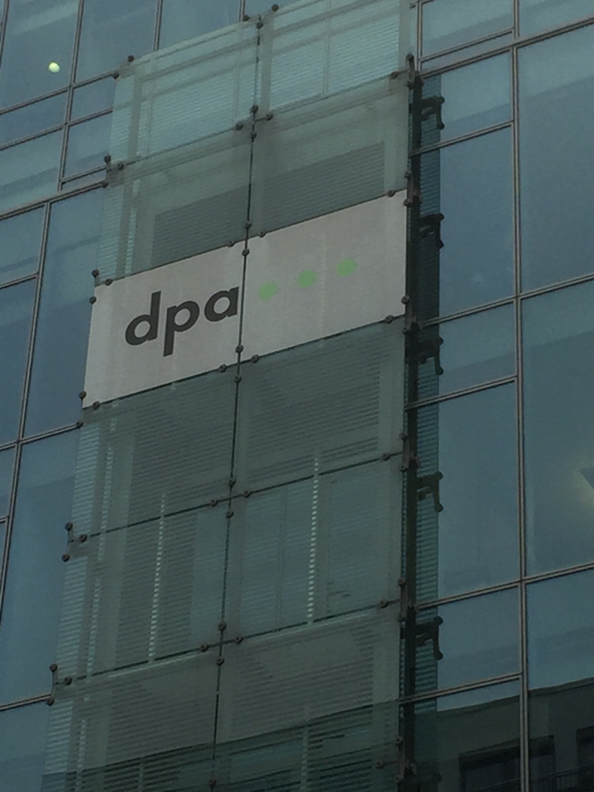 Das Gebäude der dpa in Berlin von Außen, ein Ausschnitt mit dem Logo der dpa – Glänzende Fassaden verstecken Honorarmisere: dpa | Foto: Hirschler